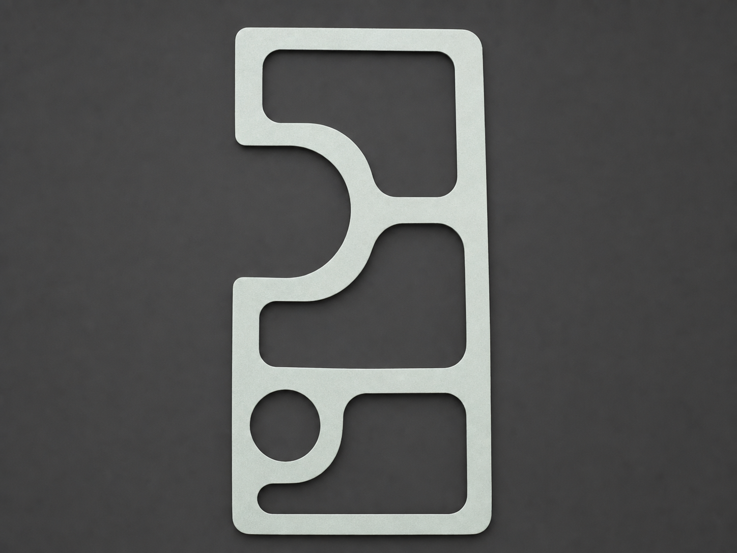 Precision die-cut pale gasket with complex rounded slots and a circular opening